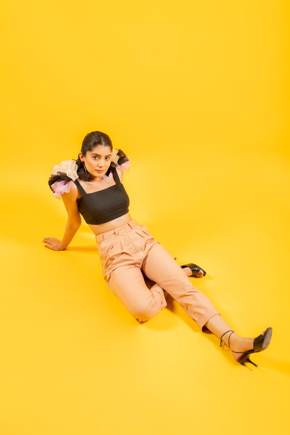 Black Ruffled Shoulder Drama Top With Tan Trousers